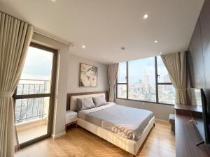 ein Schlafzimmer mit Bett und großen Fenstern in der Unterkunft Summerset Saigon - The Perfect Place to Live in District 1 in Ho-Chi-Minh-Stadt
