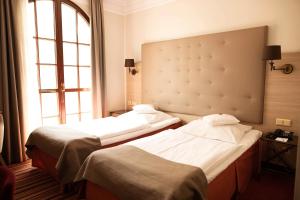 a hotel room with two beds and a window at Hotel Branicki in Białystok