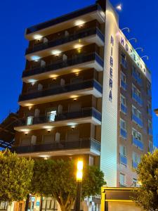 サンティアゴ・デ・ラ・リベラにあるHotel Riberaの目の前に街灯が灯る高層ビル