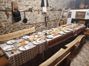 a long table with plates of food on it at Villa Old House BN in Bitola