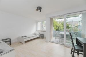 a white room with a bed and a table and a balcony at NT01 schönes Appartement - ideal für Teams Self Check-In in Nürtingen