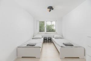 three beds in a white room with a window at NT01 schönes Appartement - ideal für Teams Self Check-In in Nürtingen
