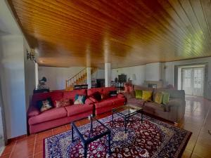un soggiorno con divano rosso e tavolo di Casa de Simaens a Felgueiras
