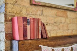 rząd książek siedzących na półce w obiekcie Beautiful 2-Bed Victorian House in Stamford w mieście Stamford