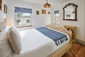 1 dormitorio con 1 cama blanca grande y espejo en Beautiful 2-Bed Victorian House in Stamford, en Stamford
