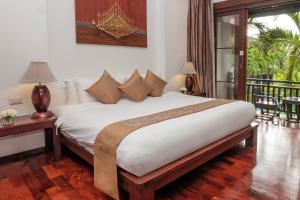 um quarto com uma grande cama branca e uma varanda em Green Park Boutique Hotel em Vientiane