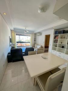 - une salle à manger et un salon avec une table et des chaises dans l'établissement Apartamento com Varanda e Suíte Enseada Guarujá, à Guarujá
