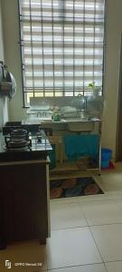 une cuisine avec une table et une cuisinière ainsi qu'une fenêtre dans l'établissement RW segamat homestay, à Segamat