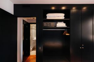 バルセロナにあるTSA Sepulvedaのクローゼット、ベッド、バスルームが備わる黒い部屋です。