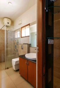 La salle de bains est pourvue d'un lavabo, de toilettes et d'une douche. dans l'établissement Tulip Villa, à Bangalore