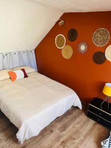 a bedroom with a white bed and a orange wall at MS Duplex in Corbeil-Essonnes