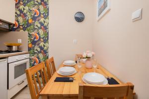 a kitchen with a wooden table with plates on it at Apartament Dlugie Ogrody Gdansk Downtown by Renters in Gdańsk