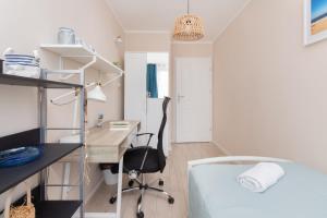 a bedroom with a bed and a desk and a desk at Apartament Dlugie Ogrody Gdansk Downtown by Renters in Gdańsk