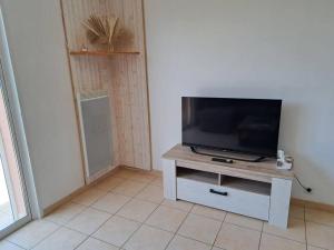a flat screen tv sitting on a stand in a room at Le Nature in Huisnes-sur-Mer