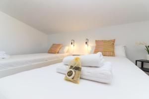 - une chambre avec un lit blanc et des serviettes dans l'établissement Chalet para 12 personas con piscina en Illescas Toledo, à El Viso de San Juan