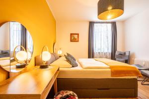 - une chambre avec un lit, un bureau et un miroir dans l'établissement Apartment "Deluxe" Innsbruck - Mutters, à Innsbruck