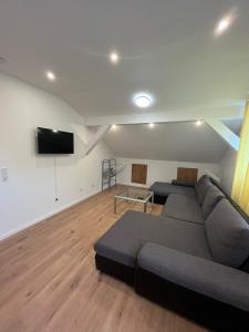 ein Wohnzimmer mit einem Sofa und einem Flachbild-TV in der Unterkunft Übernachtung by Tag in Staufenberg