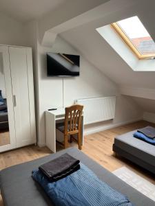 ein Schlafzimmer mit einem Bett und einem Schreibtisch im Dachgeschoss in der Unterkunft Übernachtung by Tag in Staufenberg