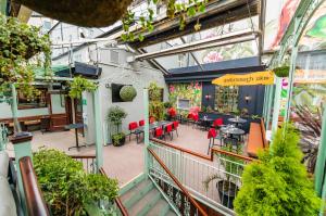 an indoor garden with tables and chairs in a building at Harcourt Hotel in Dublin +36 photos