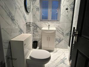 een witte badkamer met een toilet en een wastafel bij Amazing 2 Bedrooms House in Bridgend