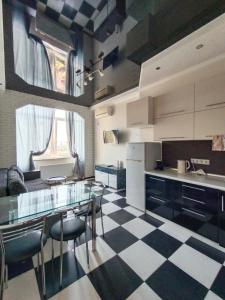 a kitchen with a checkered floor and a table and chairs at Apartments on Rudanskogo in Kyiv