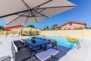a pool with a table and chairs and an umbrella at Chalet para 12 personas con piscina en Illescas Toledo in El Viso de San Juan