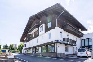 ein großes weißes Gebäude mit einem Holzdach in der Unterkunft Apartment "Deluxe" Innsbruck - Mutters in Innsbruck