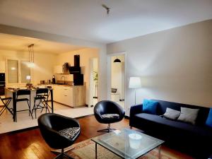Maison de charme في تولوز: غرفة معيشة مع أريكة وكراسي وطاولة