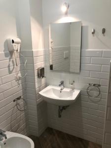 biała łazienka z umywalką i lustrem w obiekcie Rent Rooms Colosseum w Rzymie +11 zdjęć