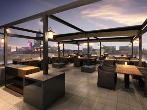d'un bar sur le toit avec des tables et des chaises et une vue sur la ville. dans l'établissement The Rise Osaka Namba, à Osaka