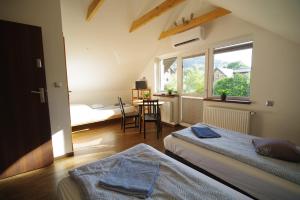 a bedroom with two beds and a table and a window at Ski House Szczyrk - Centrum in Szczyrk