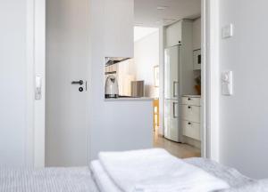 a white room with a kitchen and a bed at 2ndhomes Tampere "Lumilinna" Apartment - 1BR New Apt in the Heart of the City in Tampere