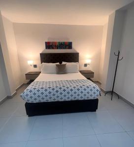 a bedroom with a large bed with two lamps at Hotel Zuriel Boutique in Cartagena de Indias