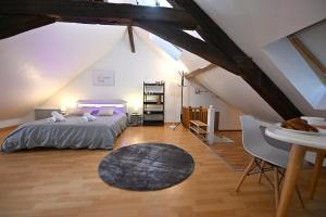 a attic bedroom with a bed and a table at Le Cosy du tambour d'argent in Sens