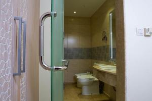 uma casa de banho com um WC e um lavatório em Toledo Amman Hotel em Amã