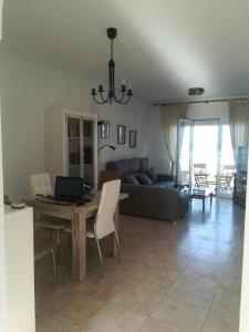 een woonkamer met een bank en een tafel met een laptop bij 610 precioso apartamento cerca del mar in Los Amarguillos
