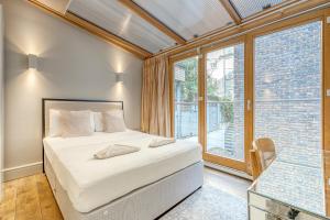 a bedroom with a bed and a large window at Stay at Piccadilly in London