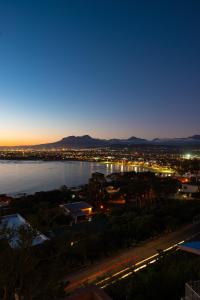 a view of a city and a river at night at Palm Tree Self-Catering Apartment in Gordonʼs Bay