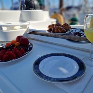 Una mesa con un plato de fruta y una copa de vino. en UMBOLINA, en Cascais