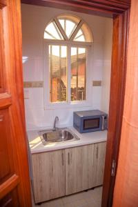 a kitchen with a sink and a microwave at RIVER APPARTS in Brazzaville