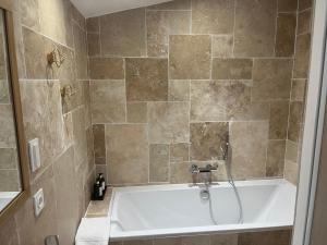 y baño con bañera y ducha. en Suite avec Sauna 36m², en Niort