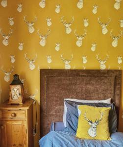 1 dormitorio con 1 cama con cabezas de ciervo en la pared en Dulrush Lodge Guest House, Restaurant and Self-Catering, en Belleek