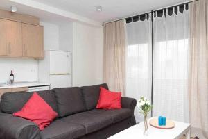 sala de estar con sofá gris y almohadas rojas en Port V Apart centrico con estilo 21 en Barcelona