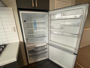 an empty refrigerator with its door open in a kitchen at Hamilton Hospital Retreat - 2 Bedroom Townhouse Modern Warm Quiet in Hamilton
