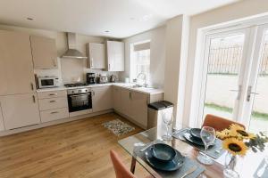 a kitchen with a table and a kitchen with a window at APPLECROFT - Escape to the Peak District National Park in Buxton