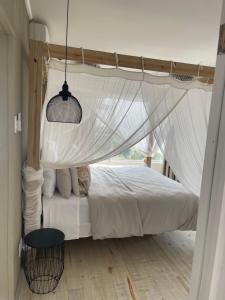 a bedroom with a white bed with a canopy at Villa 9B Signal Hill Ponta Malongane in Ponta do Ouro