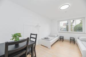a white living room with a table and a couch at NT02 schönes Appartement - ideal für Teams Self Check-In in Nürtingen