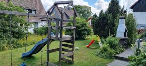 a playground with a slide in a yard at Ferienhaus Sauerzapf mit Saunabereich 16 Personen in Braunlage