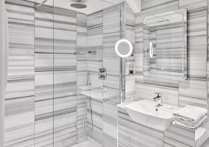 a bathroom with two sinks and a glass shower at Warren House Hotel in Kingston upon Thames +29 photos