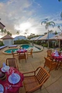 a patio with tables and chairs next to a pool at Baan Chong Fa Resort in Khao Lak